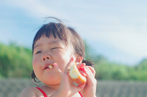 little girl eating a healthy apple snack on vacation