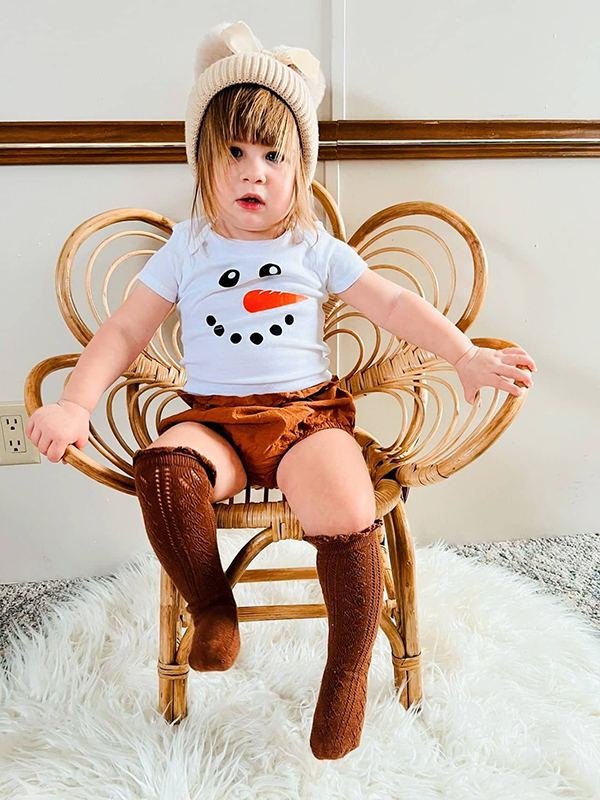 baby girl wearing a snowman onesie and matching accessories