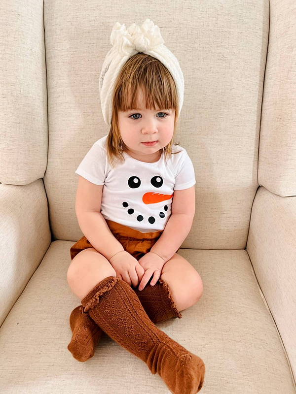 toddler girl wearing a snowman onesie
