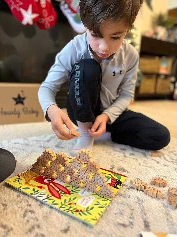 boy playing with wooden toy sorting game