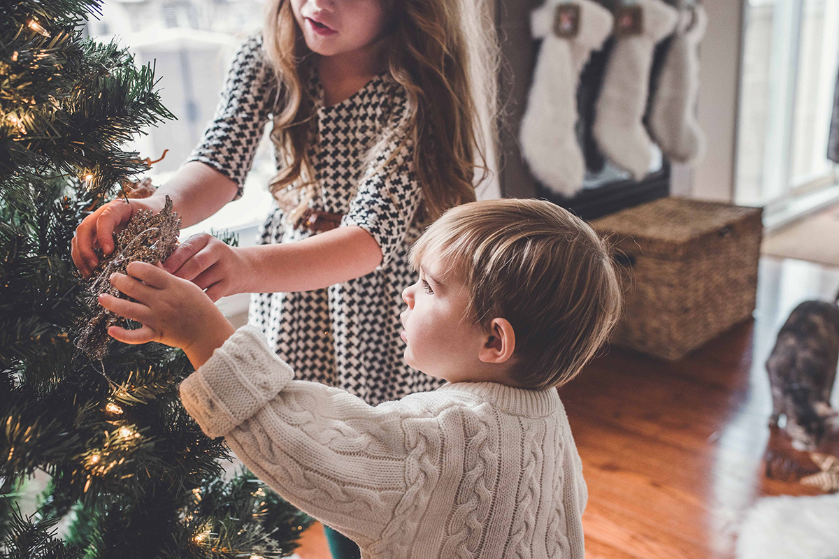 siblings decorating the tree together to manage holiday stress