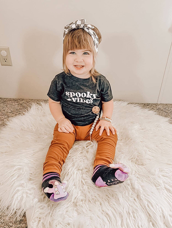 baby girl wearing a spooky vibes tee