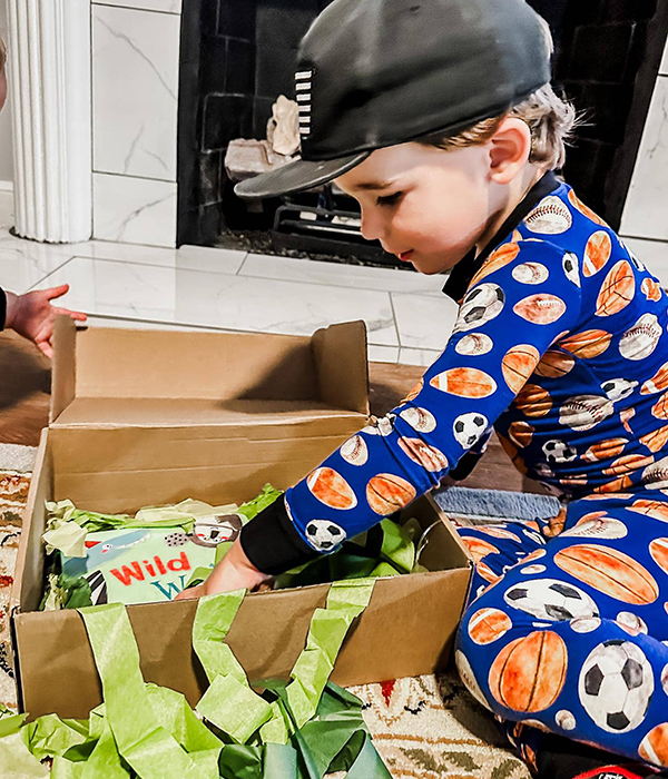 little boy opening the Howdy Baby subscription box for girls and boys