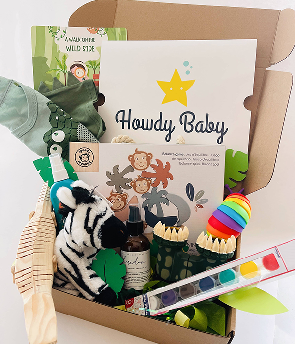 July 2023 Howdy Baby kids subscription box for girls and girls with animal balance game, wooden crocodile toy, and alligator t-shirt