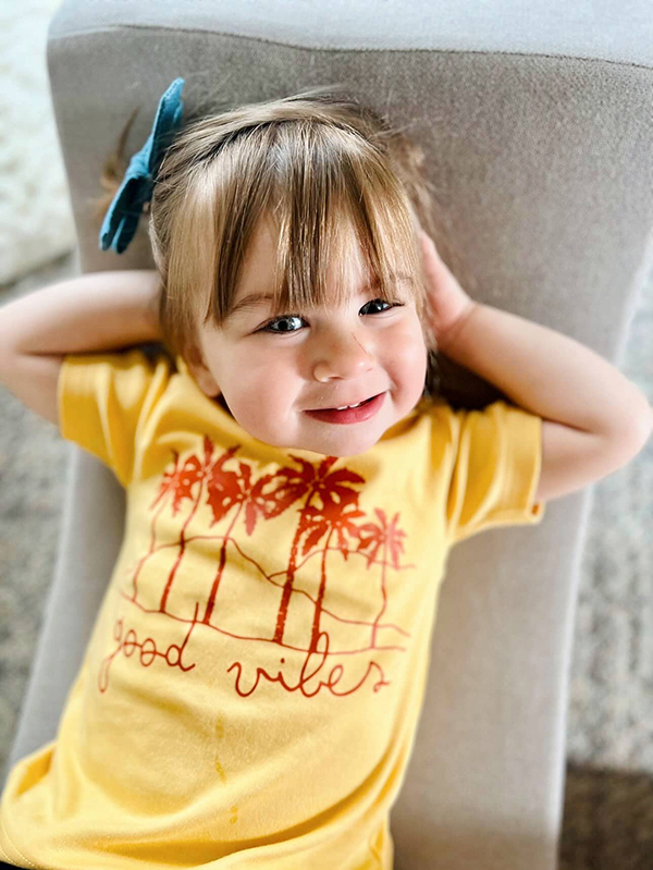 little girl wearing a yellow t shirt from the May 2023 Howdy Baby subscription box for mother's day