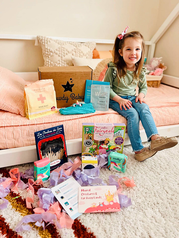 little girl opening her monthly Howdy Baby subscription boxes for kids