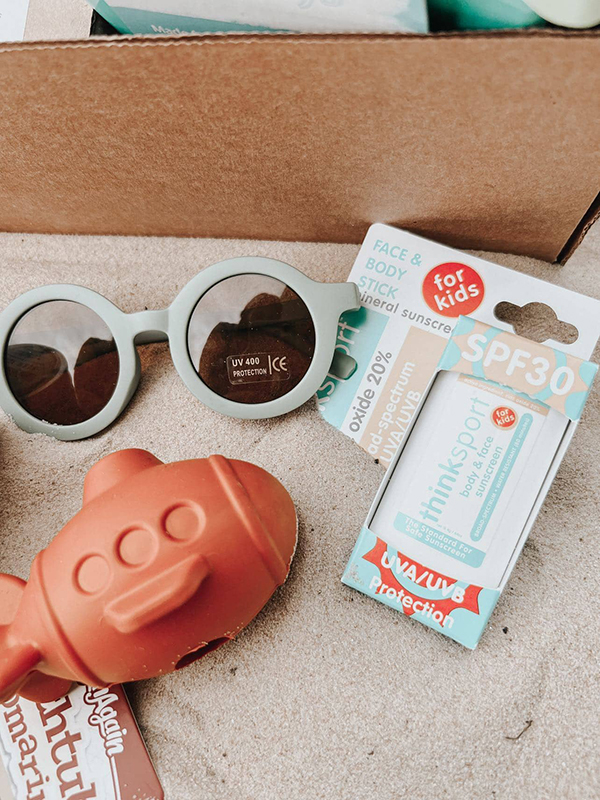 sunglasses, kids sunscreen stick and eco friendly beach toys from Howdy Baby June subscription boxes to gift