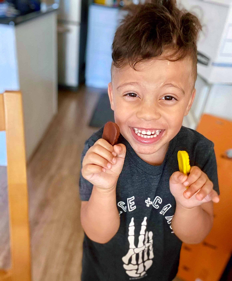 toddler boy opening monthly box subscription while wearing a Halloween outfit