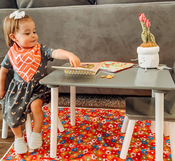 little girl sitting at a table eating snacks