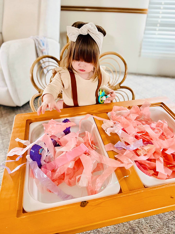 toddler girl playing with items from her Howdy Baby subscription box