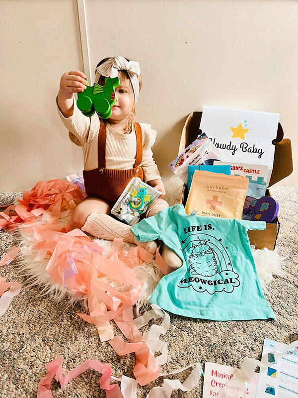 toddler girl exploring her Howdy Baby subscription box