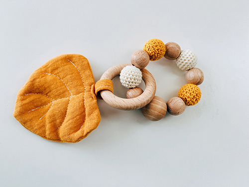 wooden teether with yellow leaf