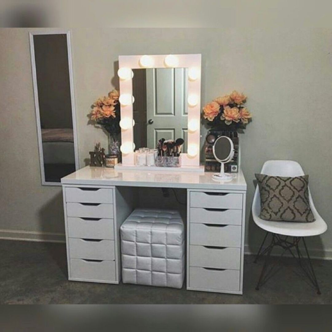 Makeup vanity with a round chair and marquis lighting around the mirror. 
