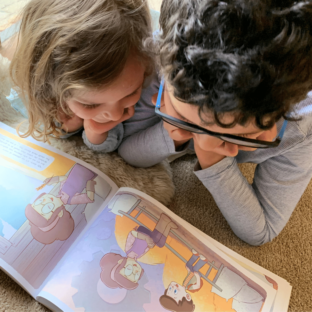 Two children lying down reading a Christian children's book