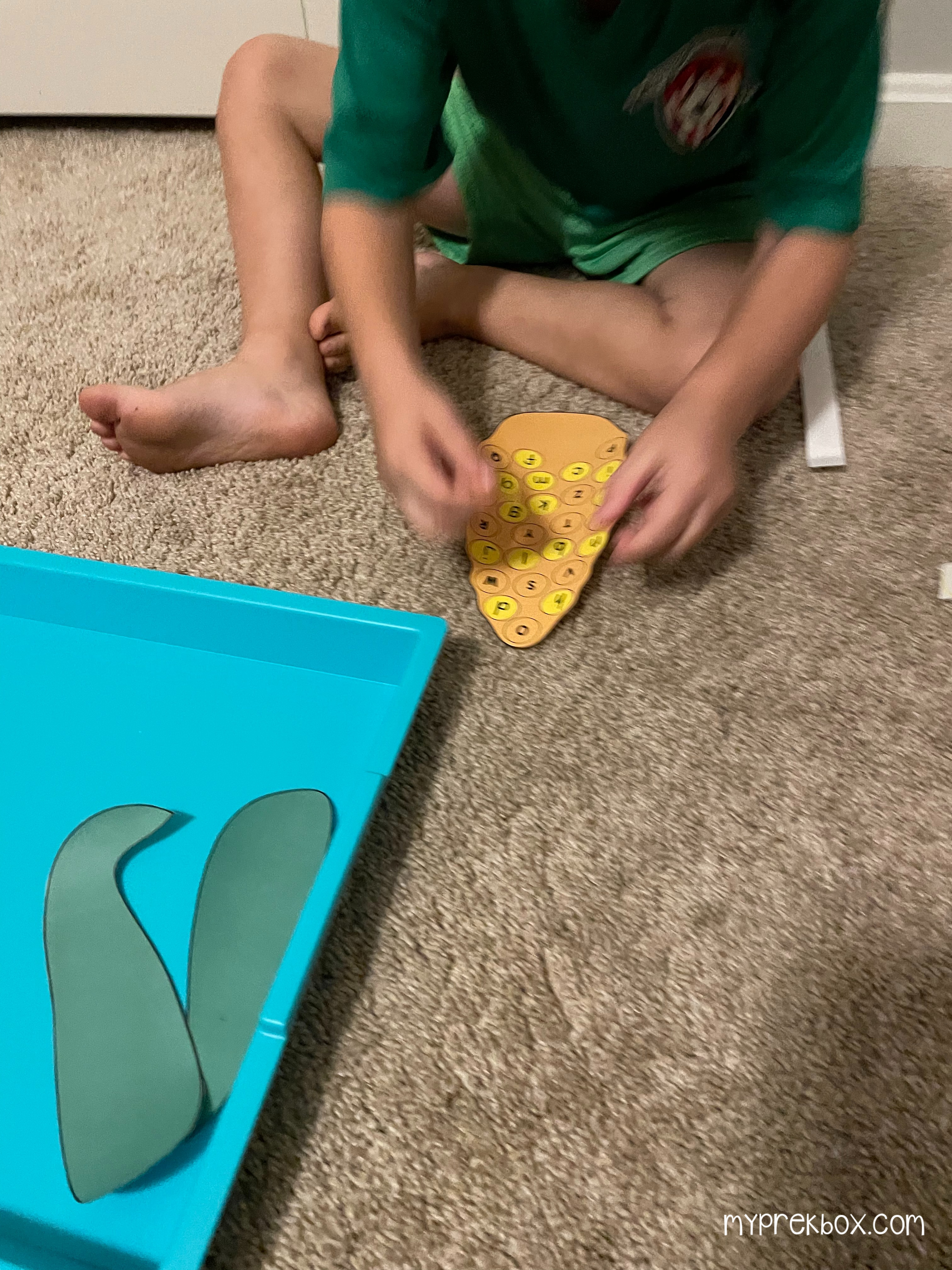 child putting letters on corn cob