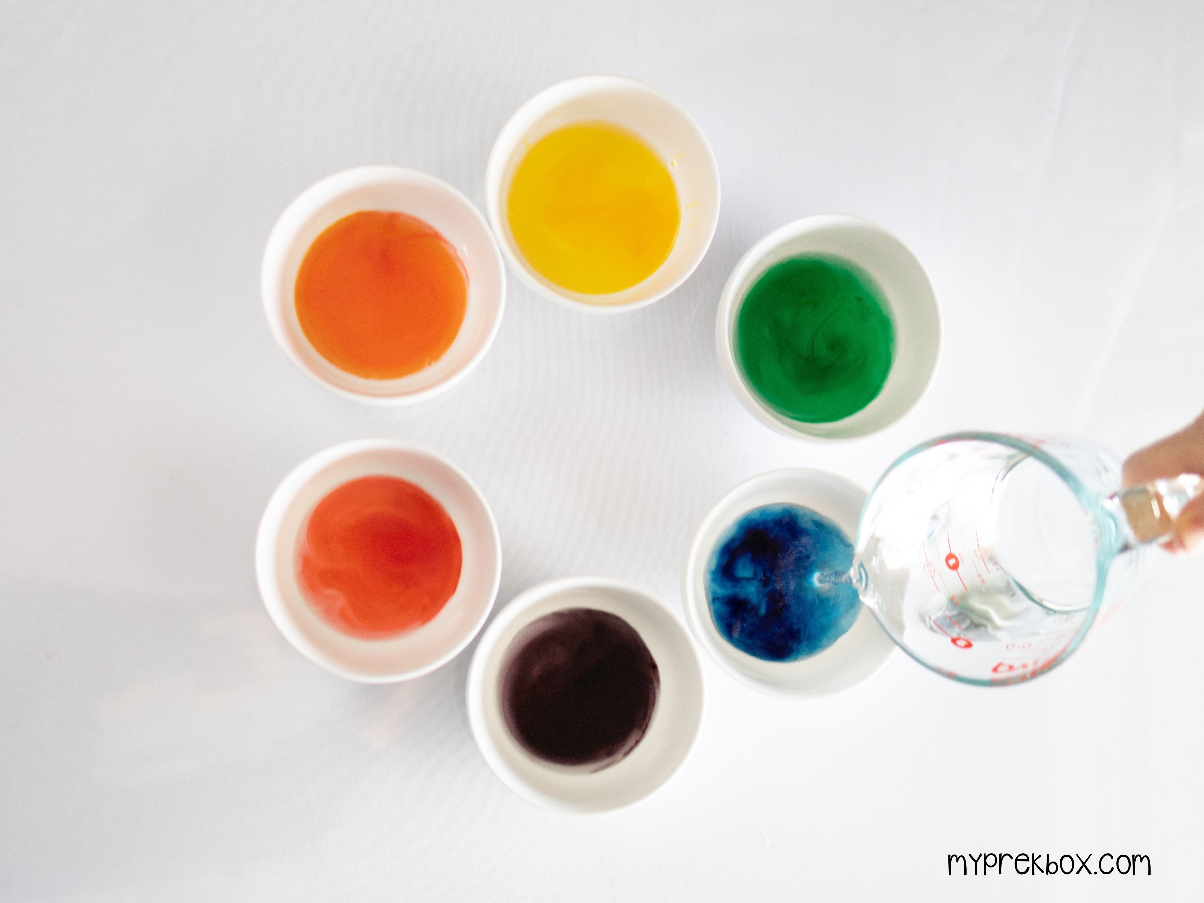 pouring water into bowls to make colored water