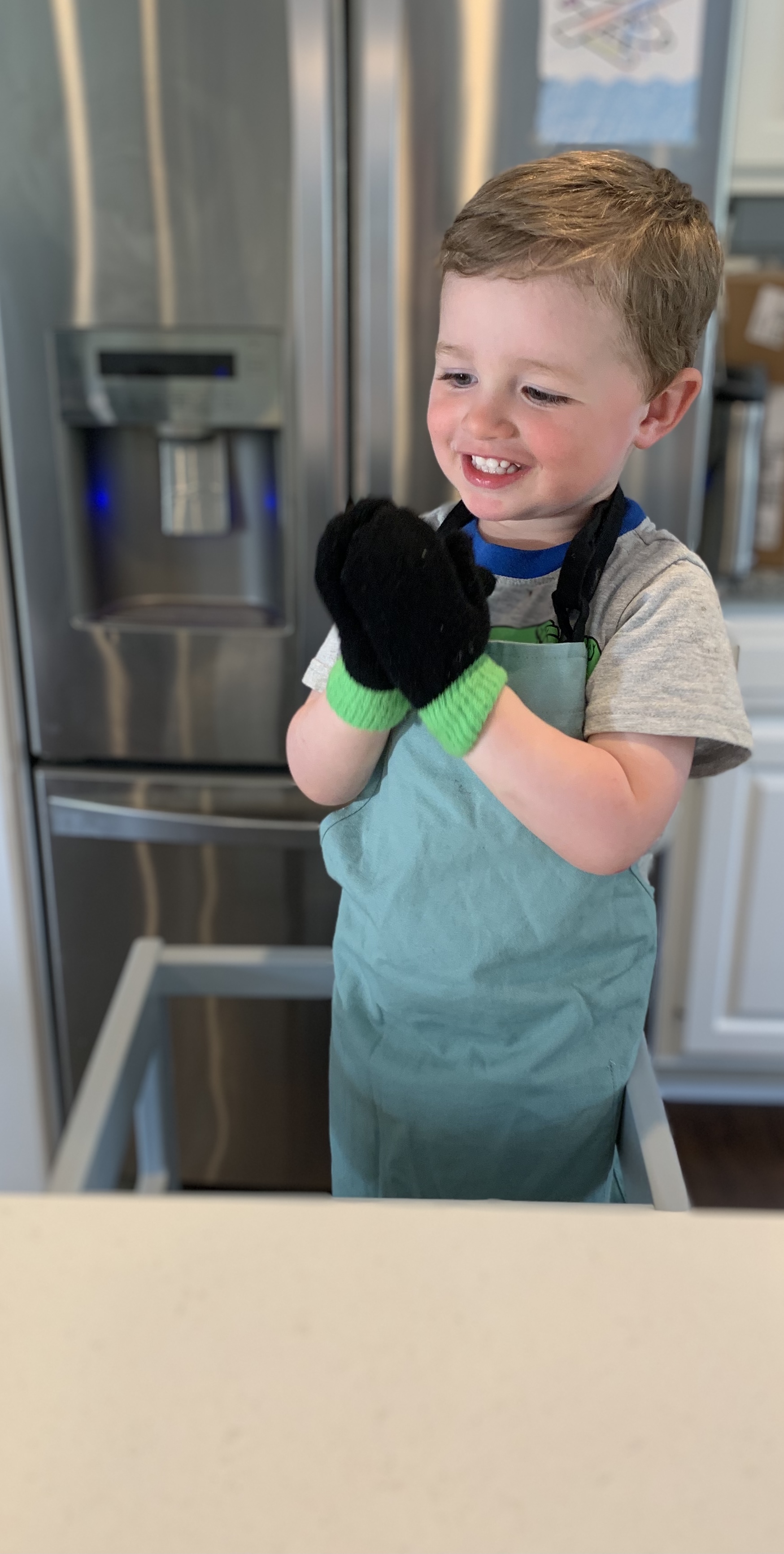 Child wearing gloves for ice cream in a bag science experiment