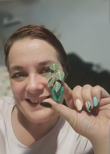 Miniature Anthurium Crystal Hope made with Nicole’s Jungle kit Smiling woman holding a miniature handmade paper Anthurium Crystal Hope plant in a green pot with a cute face