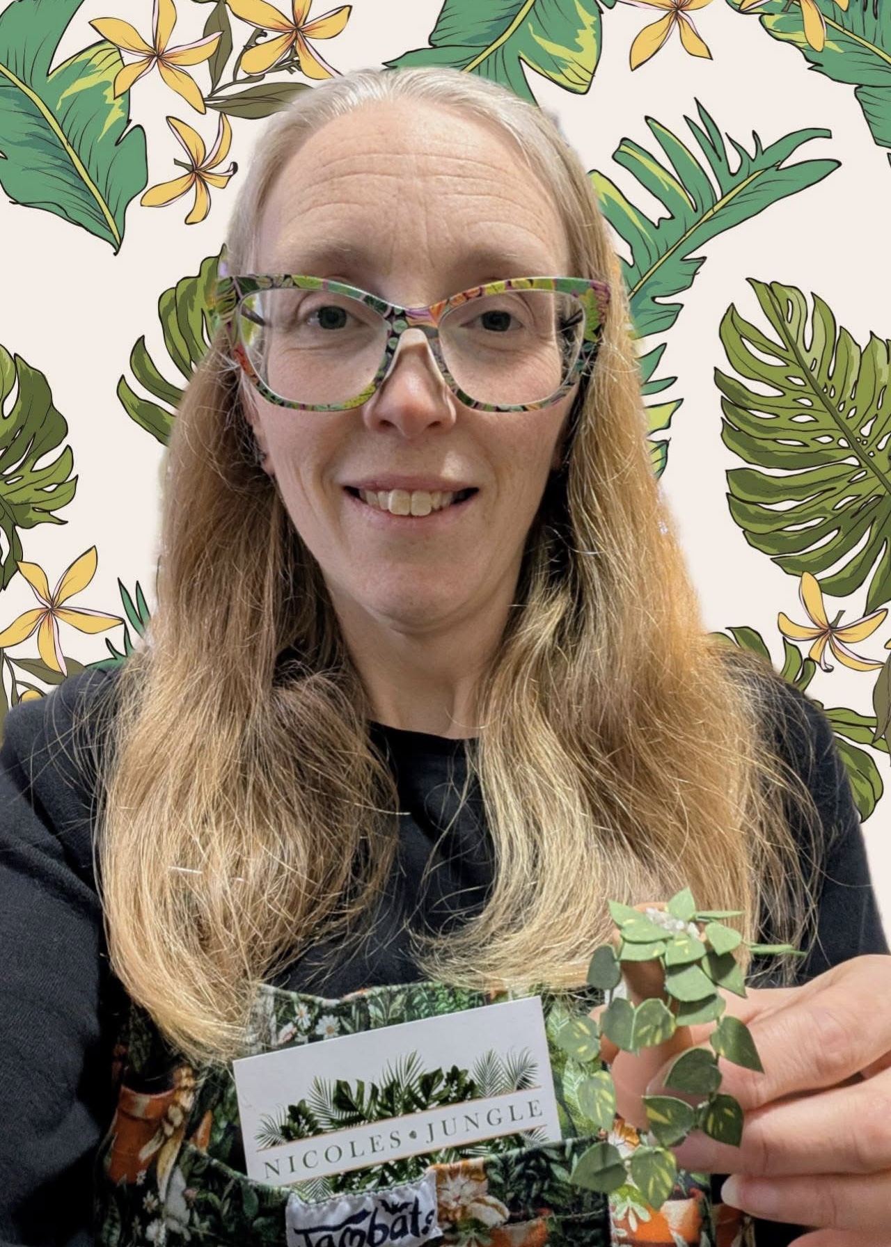 Miniature pothos paper plant made from a Nicole’s Jungle kit Smiling woman holding a miniature handmade paper pothos plant in a terracotta pot, wearing tropical print plant dungarees