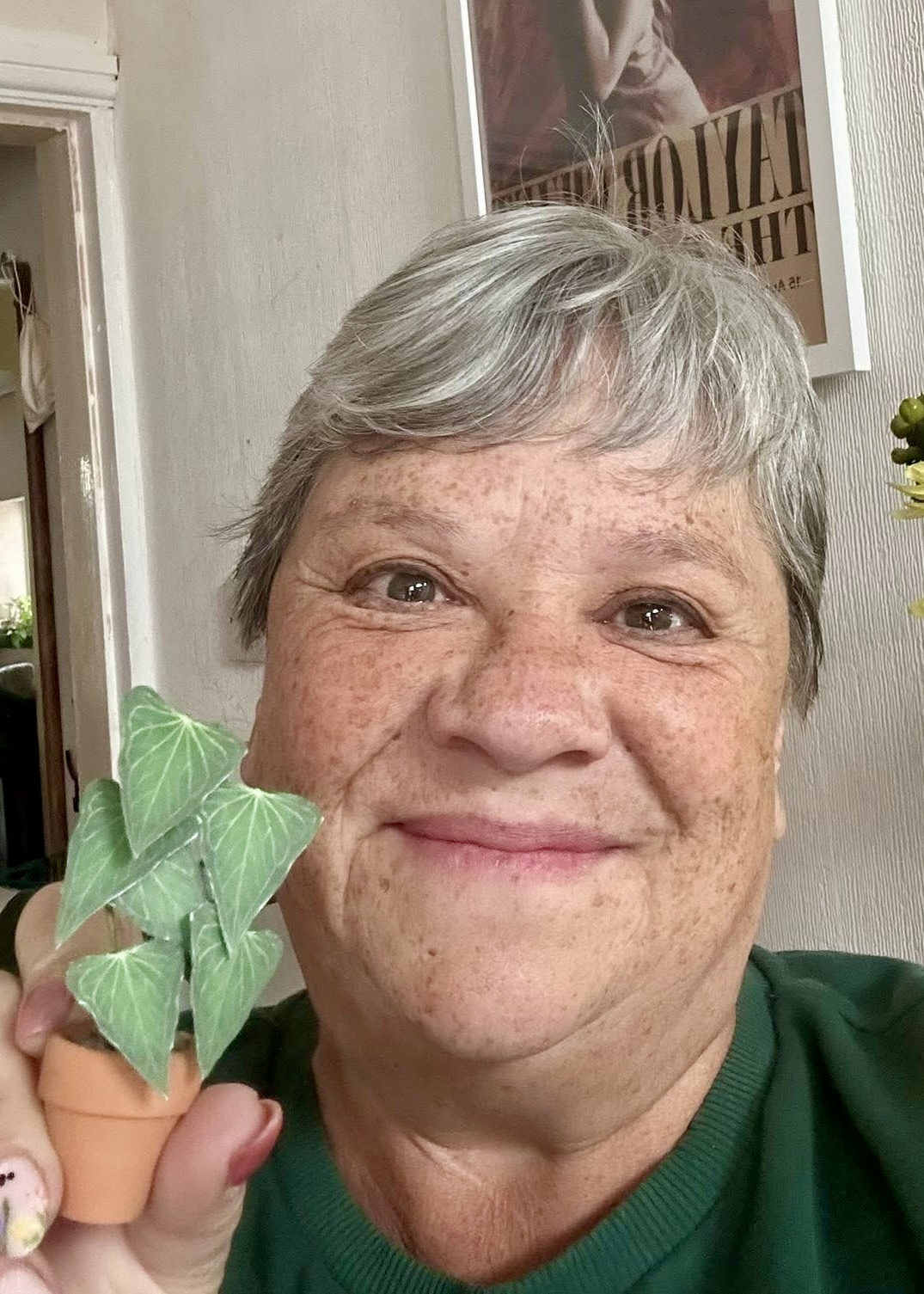 Miniature Anthurium Delta Force made with a Nicole’s Jungle kit Smiling woman holding a miniature handmade paper Anthurium Delta Force plant in a terracotta pot