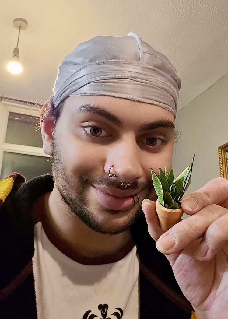 Miniature snake plant made with Nicole’s Jungle paper plant kit Smiling person holding a tiny handmade paper snake plant in a terracotta pot
