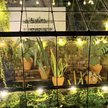 Miniature greenhouse with paper plants, moss, and lights Miniature lead and glass greenhouse filled with handmade paper plants, moss, string lights, and plant benches