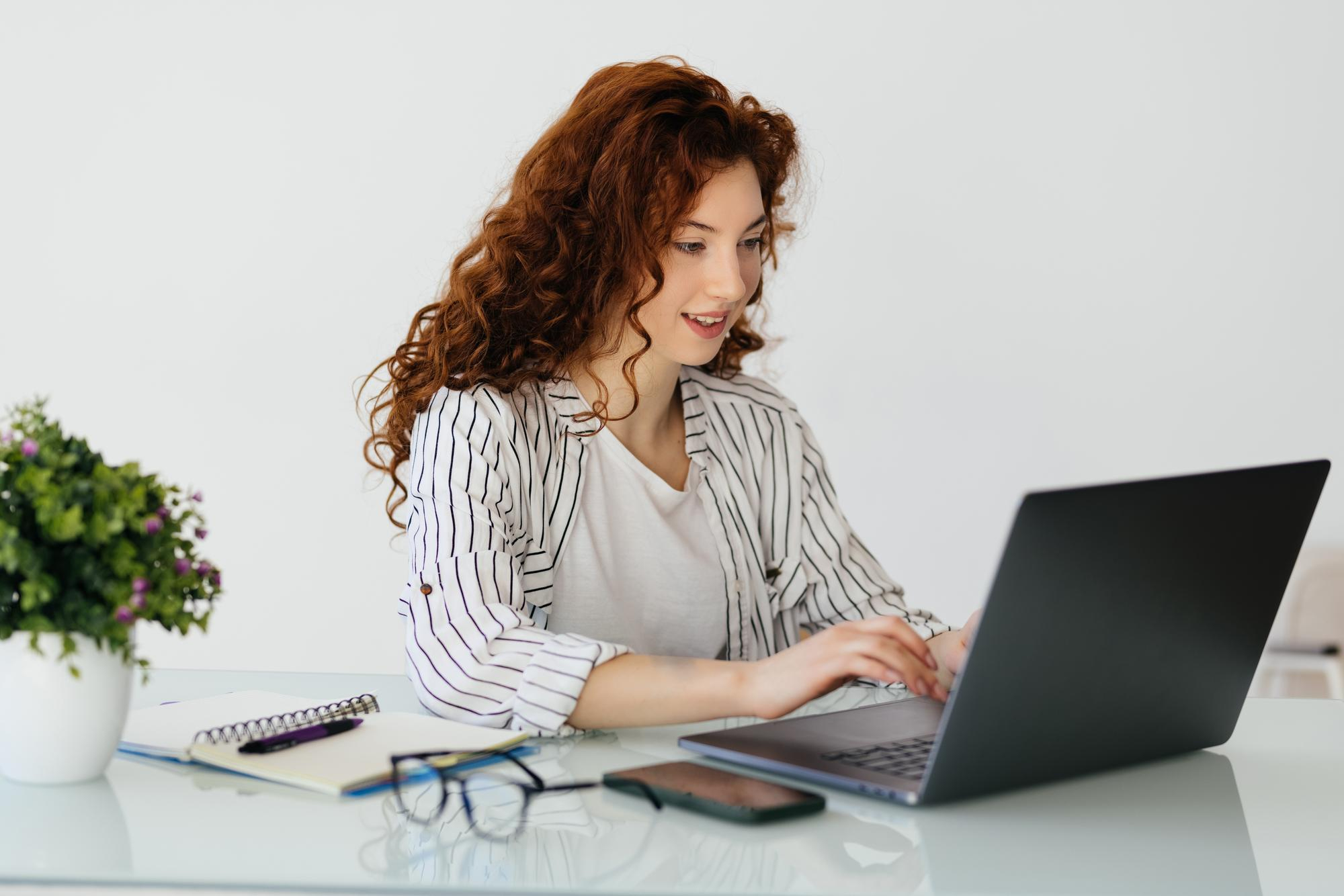 r422-ginger-woman-typing-laptop-while-sitting-desk-home-16984154579439.jpg