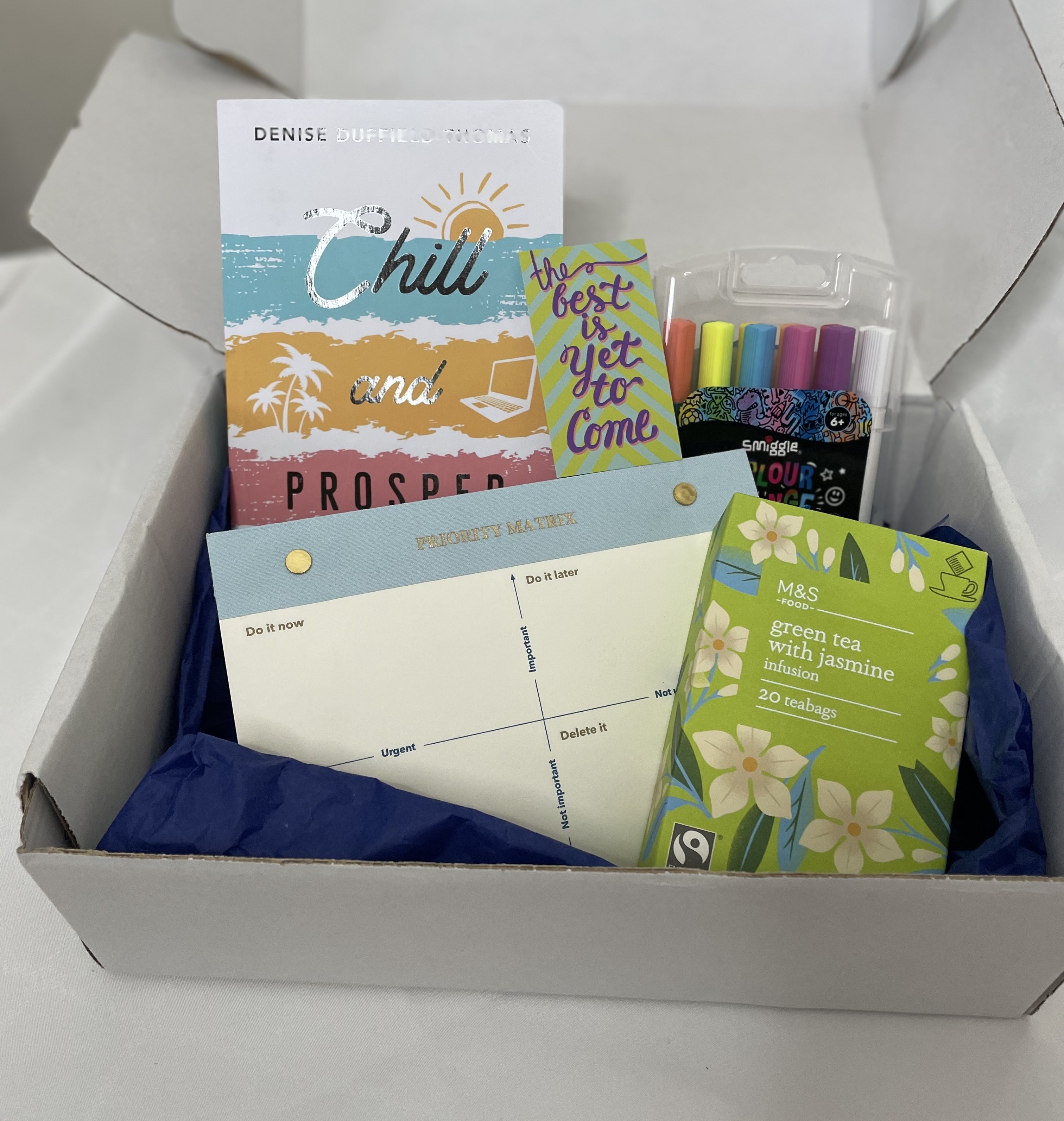 Box of stationery items including books, planners and highlighters 