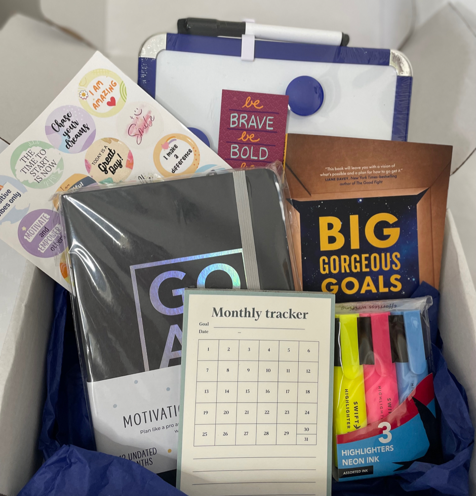 Box of stationery items including books, planners and highlighters 