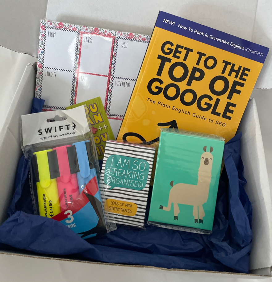 Box of stationery items including books, planners and highlighters 