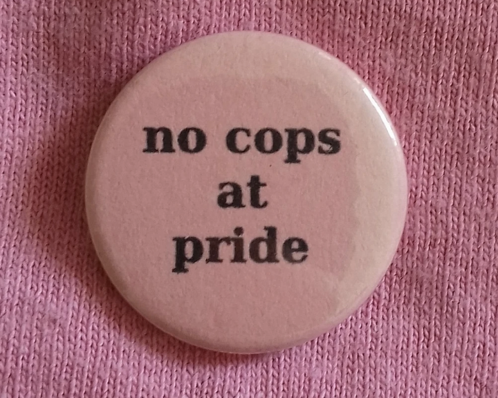 pink pin with black text saying 'no cops at pride'