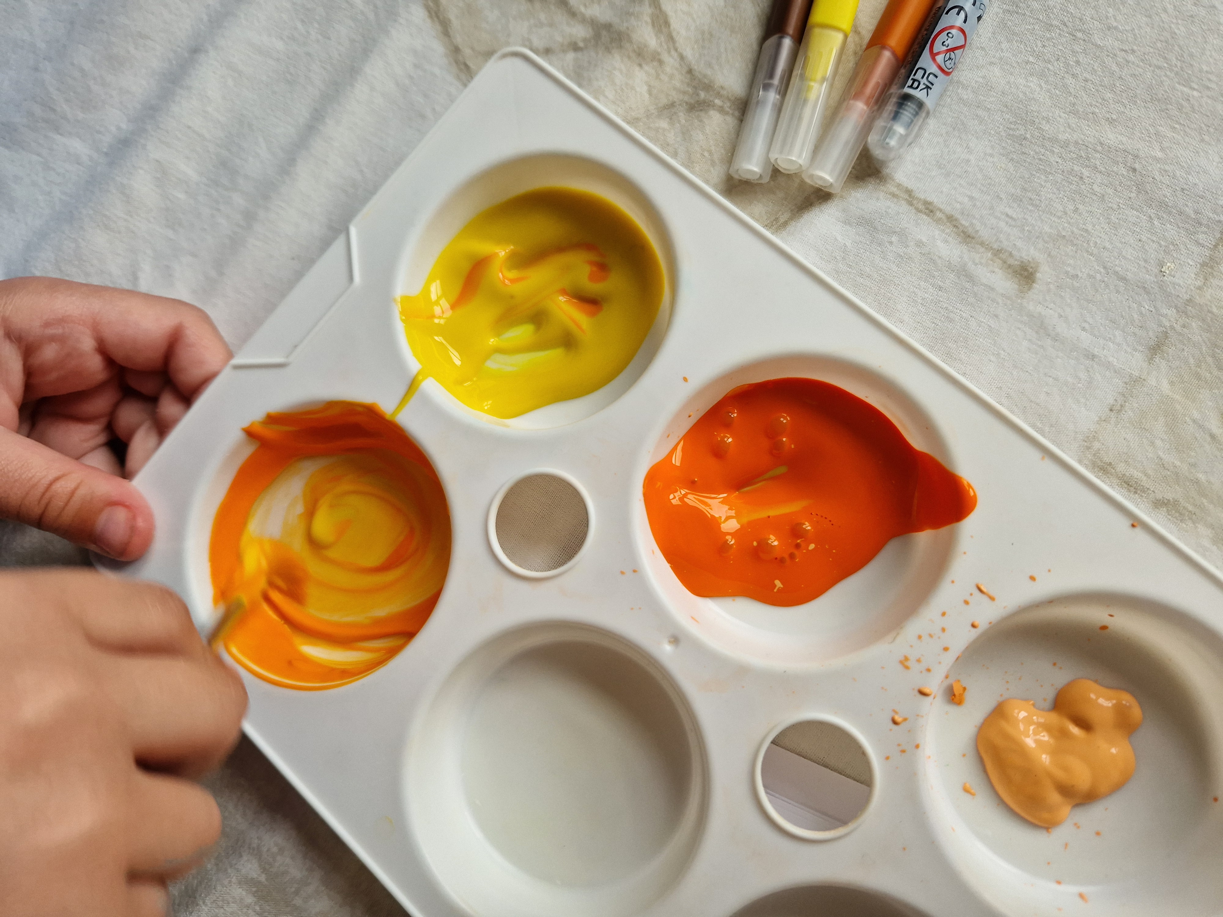 Mixing paints to create pale orange