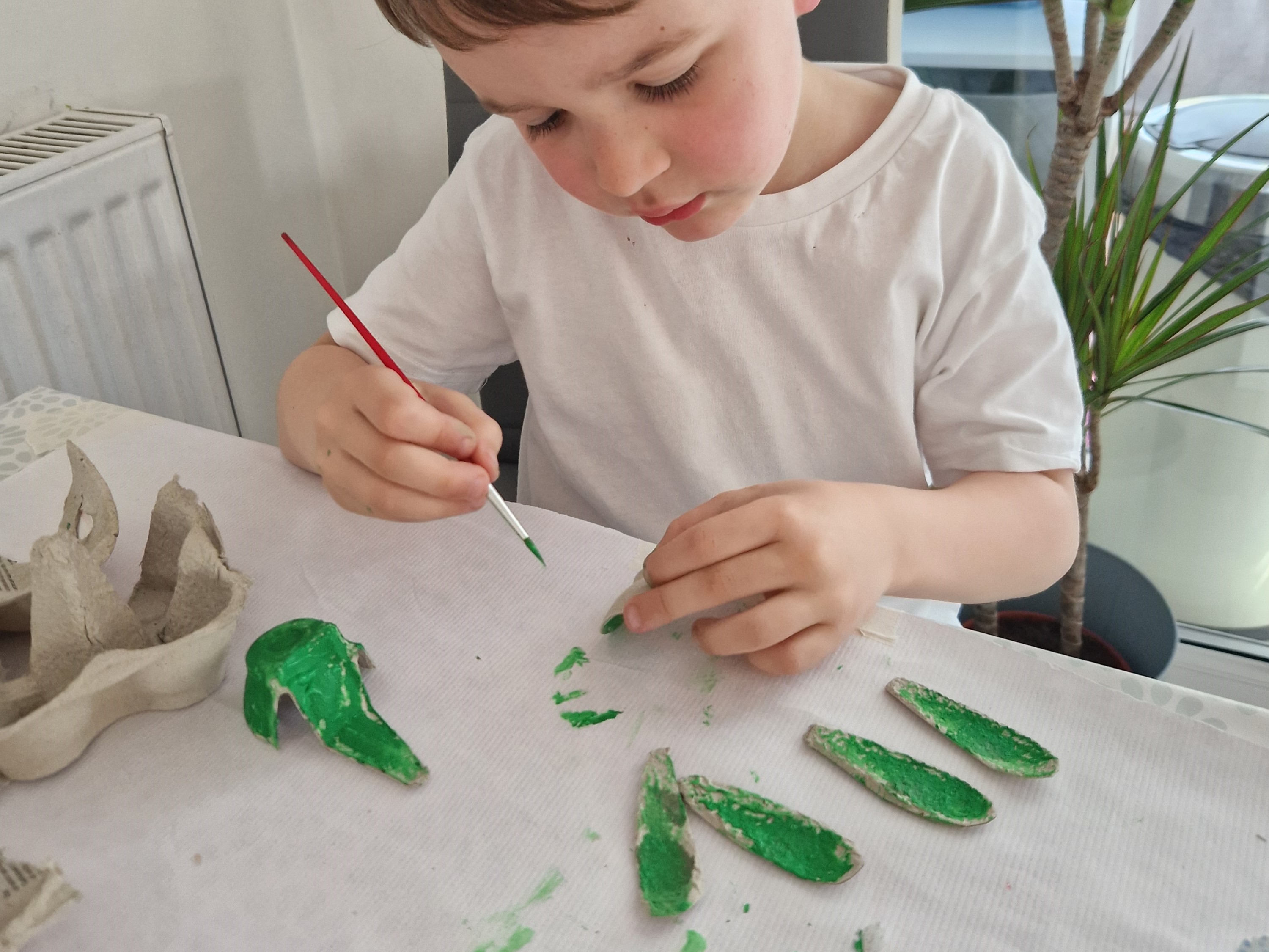 Painting egg carton pieces to make a turtle