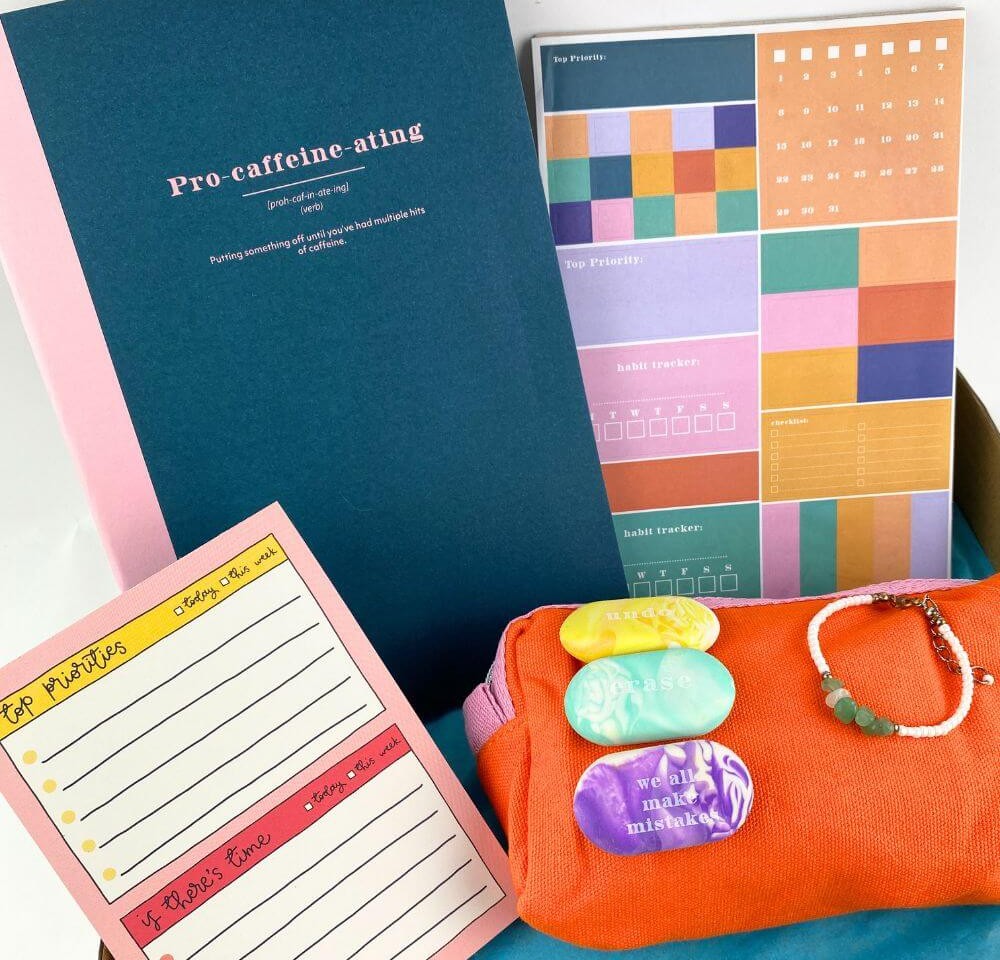 Bright and colourful sticky notes, list pads, notebooks and planners in a white box