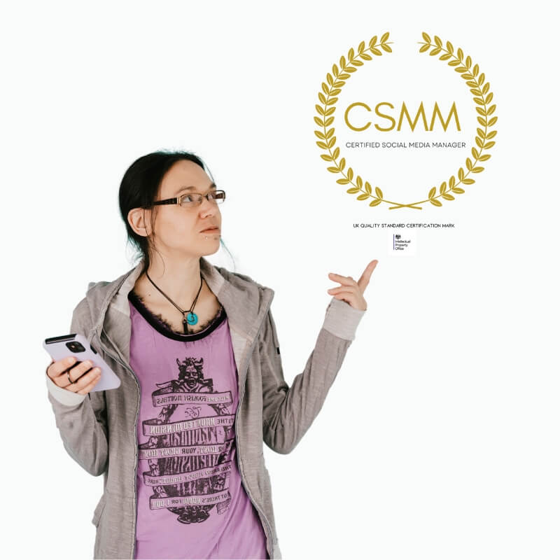Photograph of caucasian women wearing a purple tee and grey hoodie holding a purple phone and pointing at the CSMM trademart