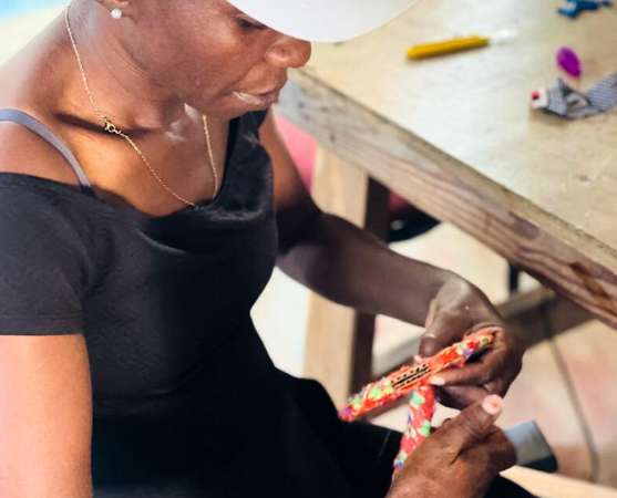 Haitian Woman Making Artisan Products 005574501318-impactmobile-17423182169336.png