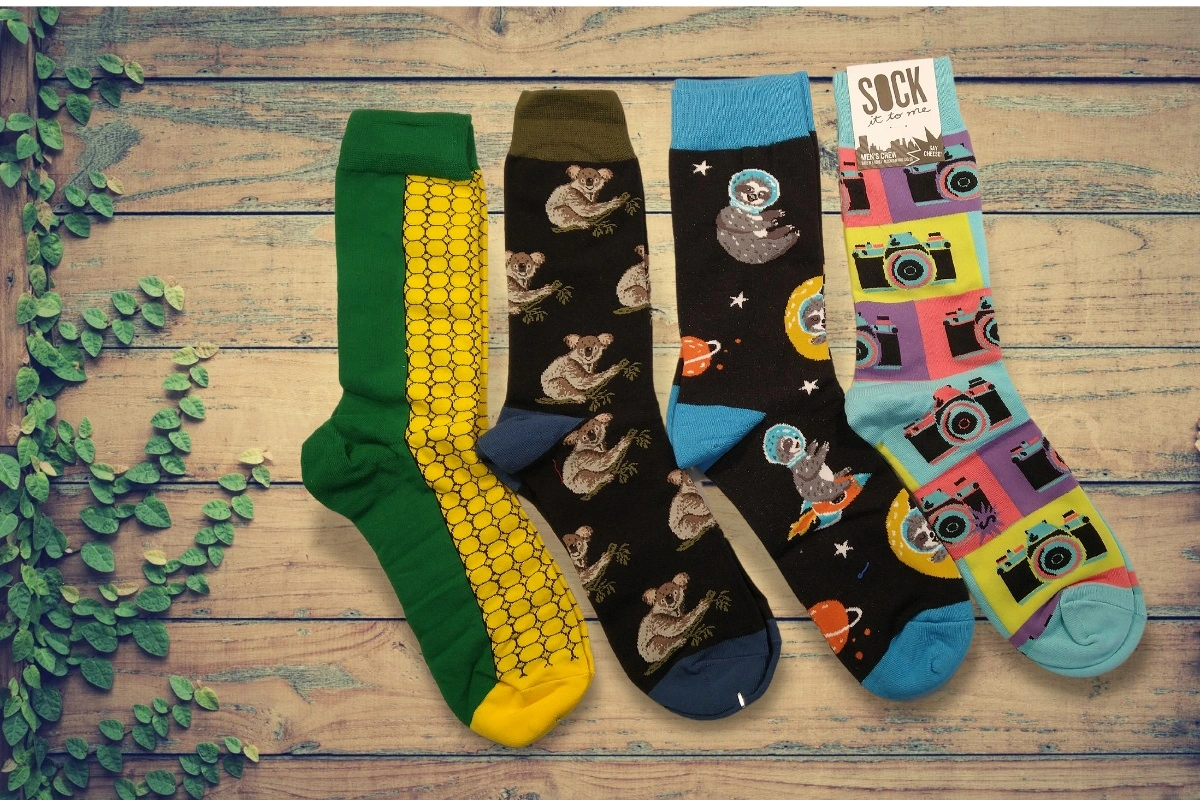 4 examples of socks in our sock subscription box. Corn sock, Koala sock, Sloth sock, Camera sock