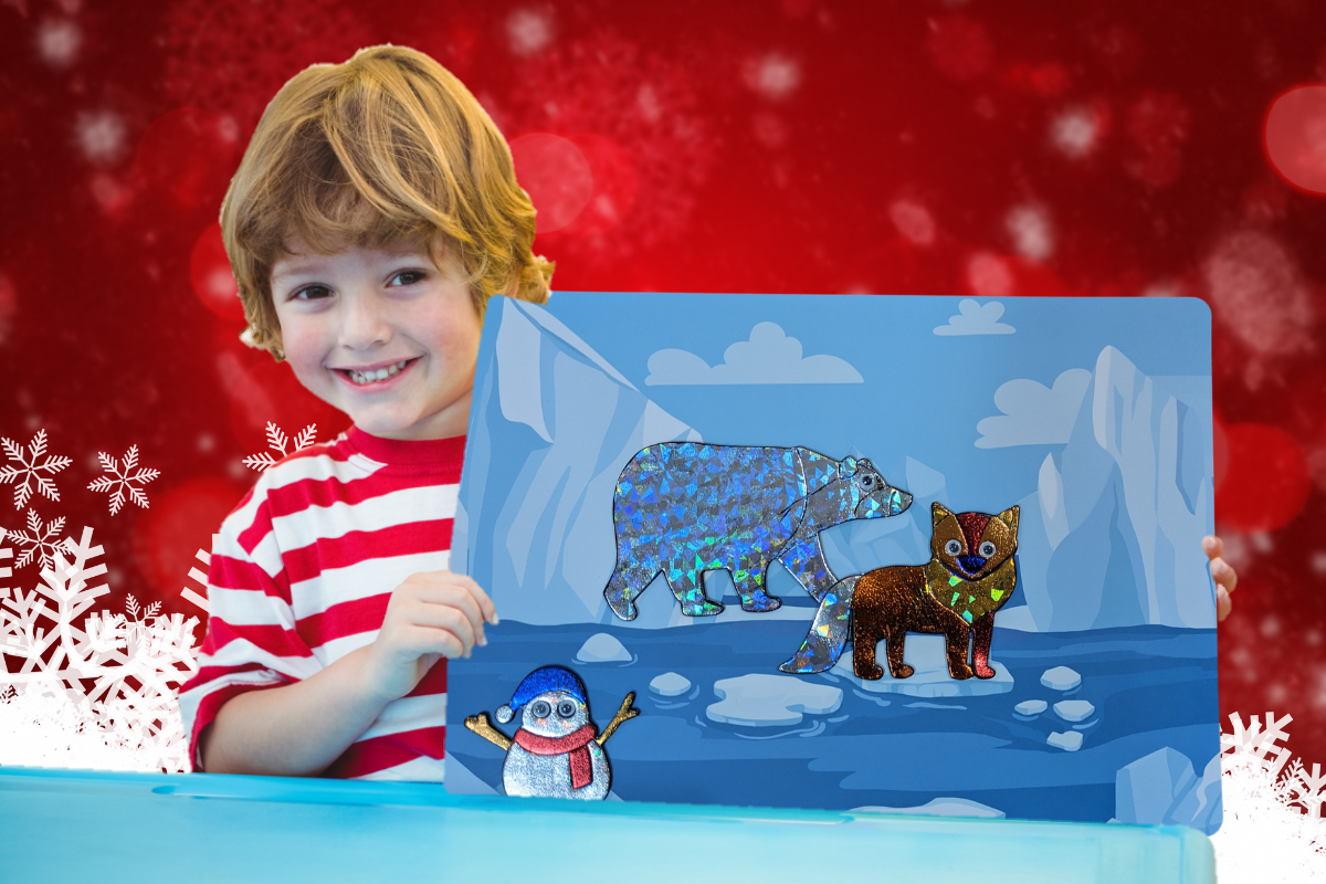 Little Boy holding a finished craft from our craft subscription box. The craft is an arctic sticker picture.
