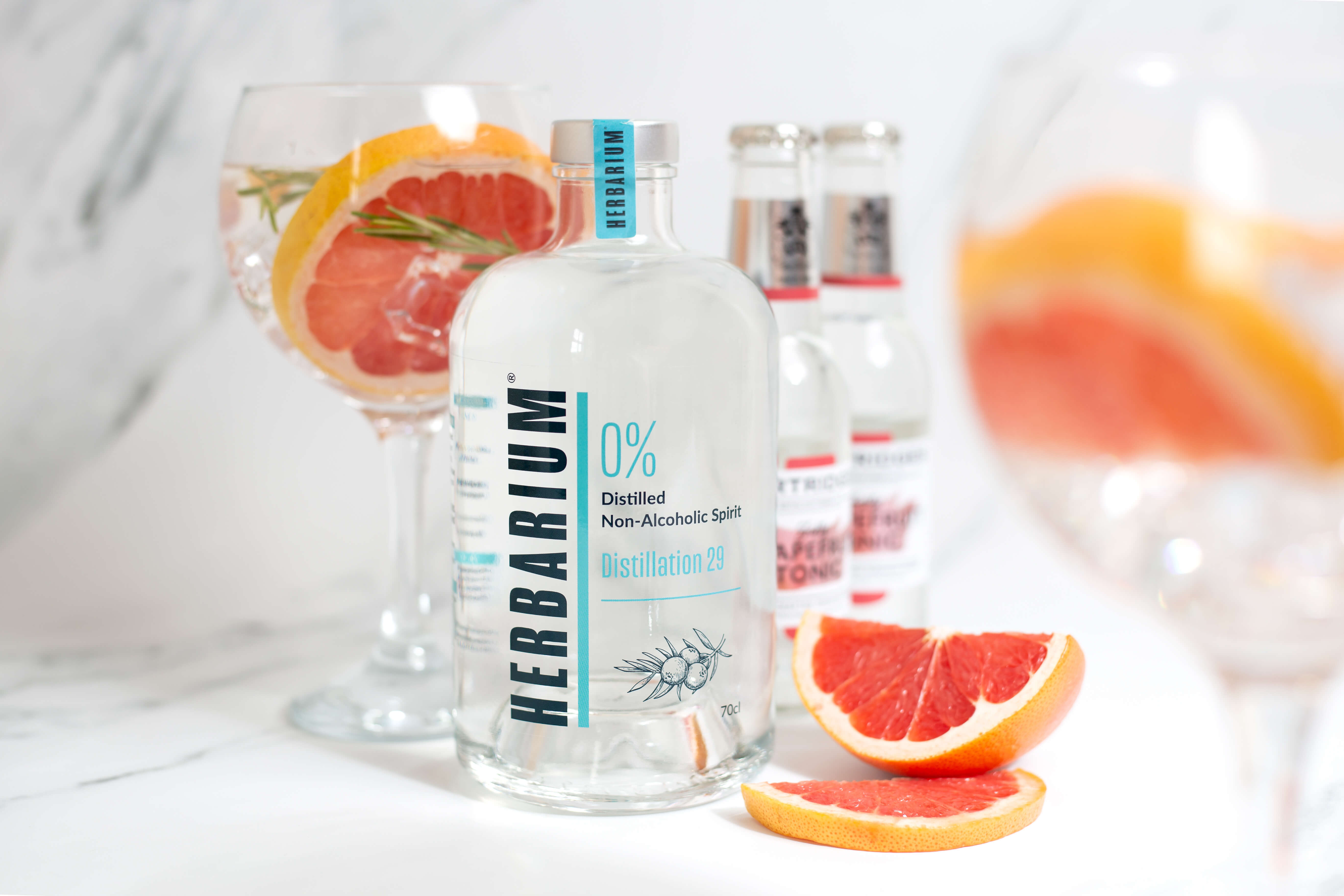 Alcohol free gin Bottle of alcohol free spirit with two bottles of tonic in the background and a perfect serve with slices of grapefruit